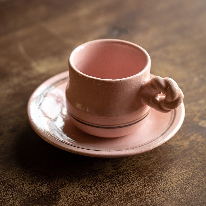 Vibrant yellow striped ceramic mug and saucer on a wooden table.