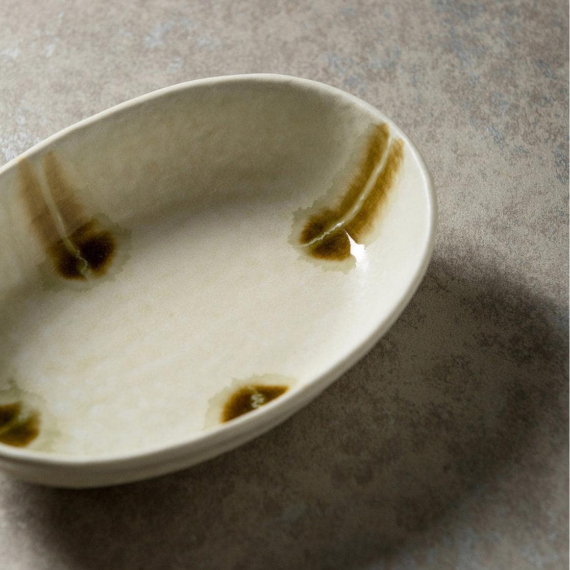 Unique oval ceramic plate with earthy texture and glaze