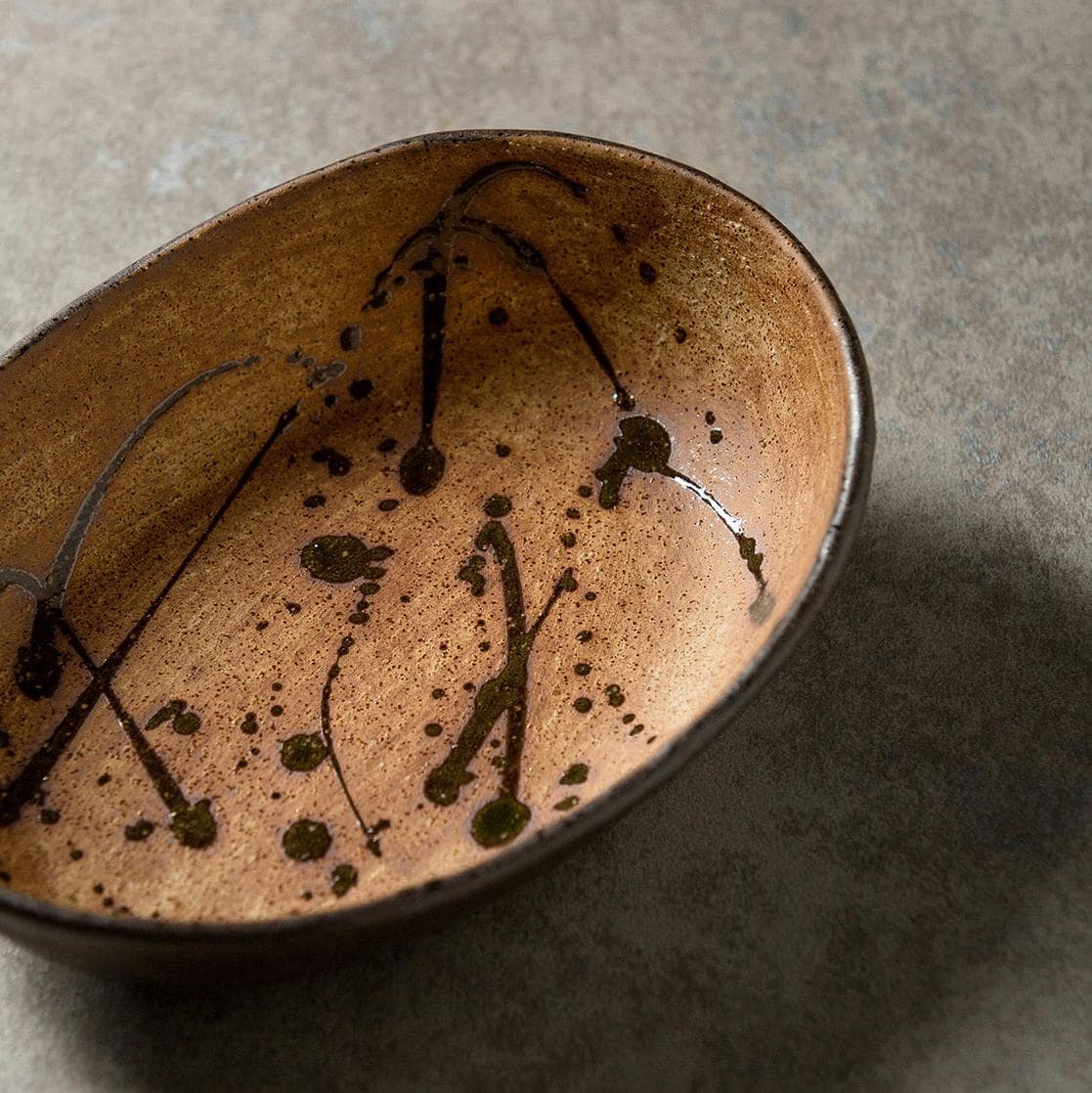 Brown and cream oval plates showcasing artistic patterns