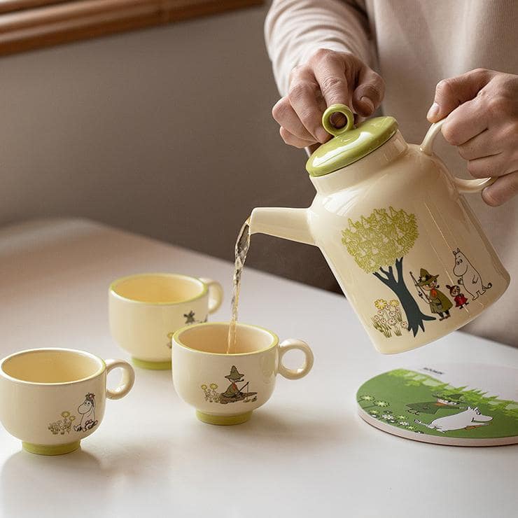 Night-sky-themed Moomin tea set with teapot and cups on a wooden tray.