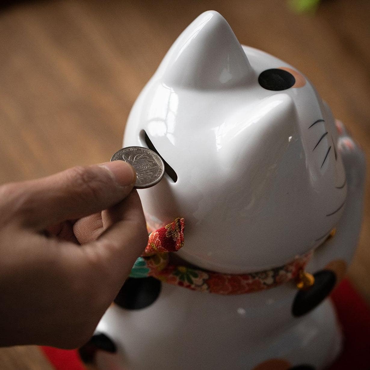 Close-up of a white ceramic lucky cat with colorful details.