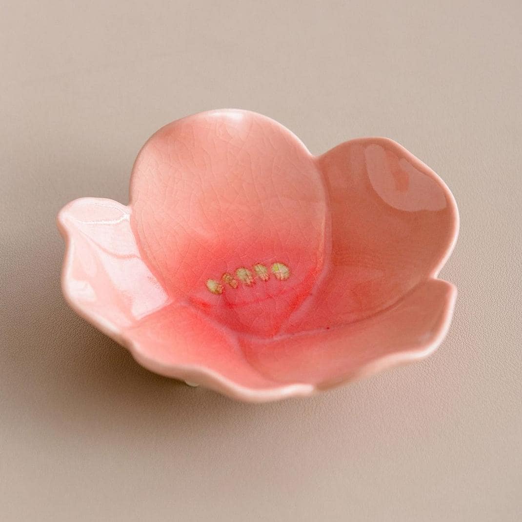 Pink flower-shaped small ceramic dish held in hands