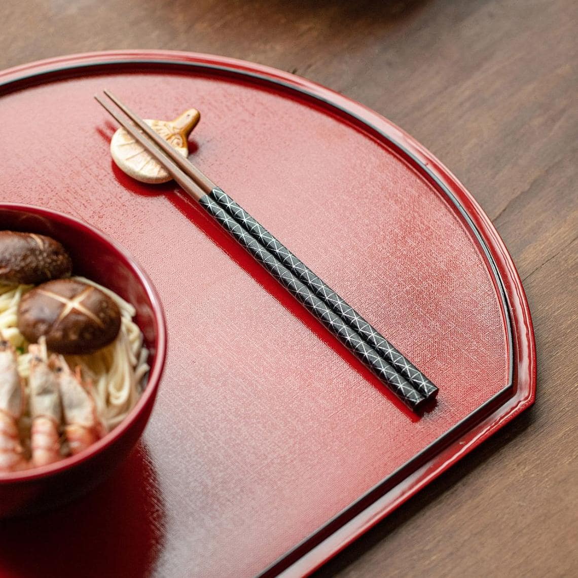 Red and black Japanese wooden star point chopsticks with geometric patterns.