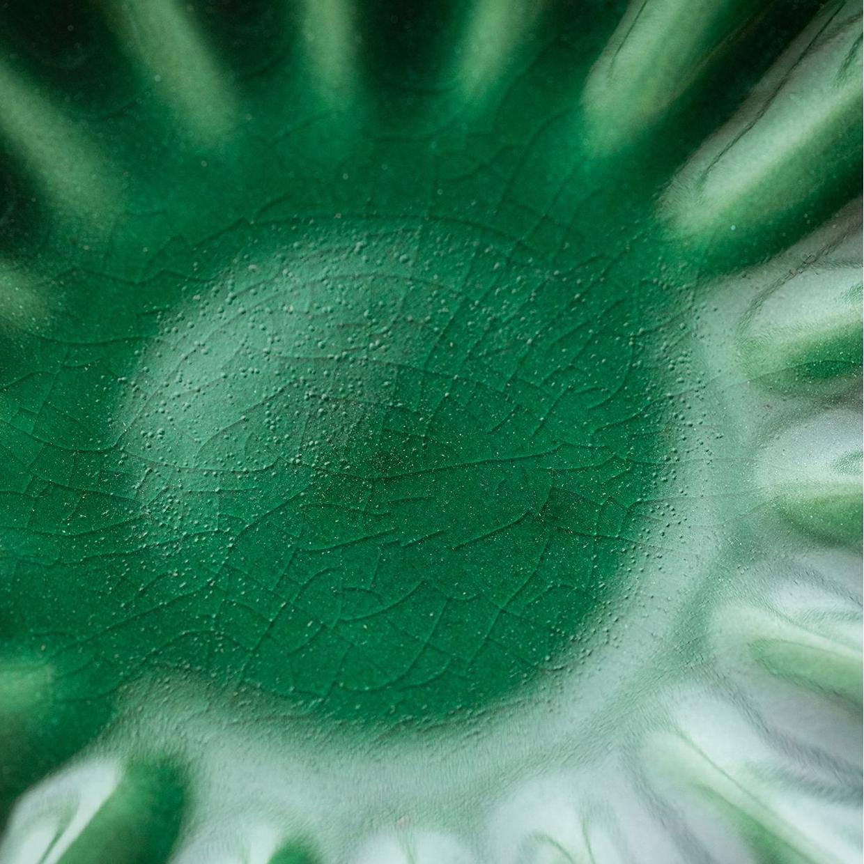 Close-up of chrysanthemum-shaped ceramic fruit plate with crackle glaze.