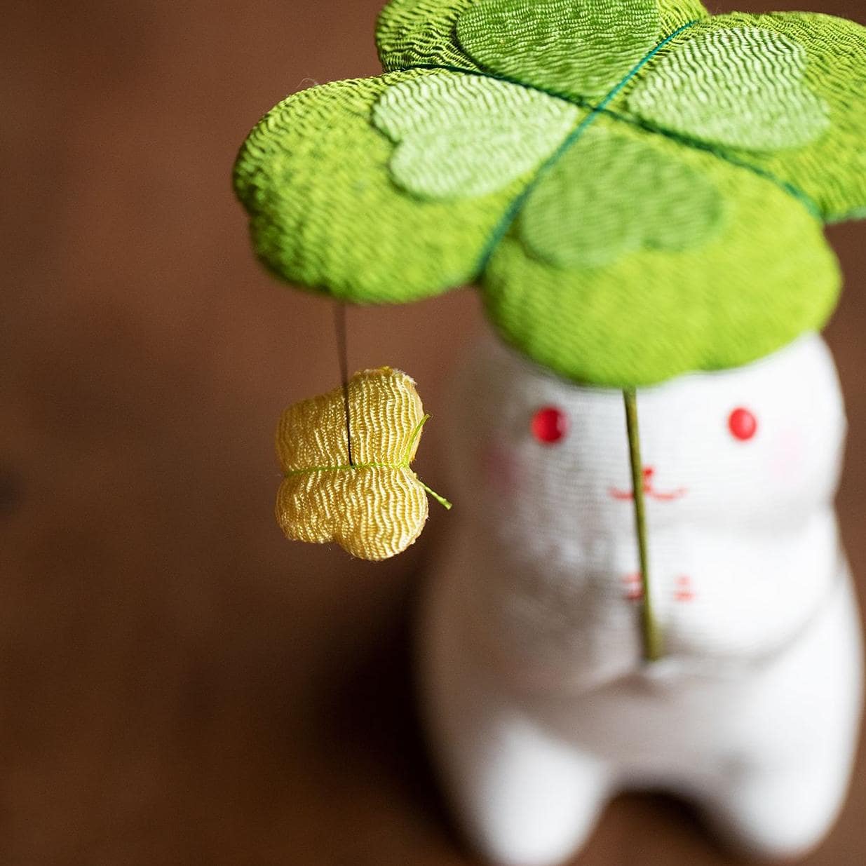 Ceramic rabbit holding a green clover umbrella, Longhutang series.