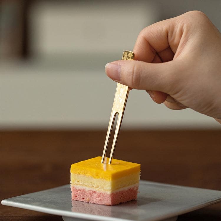 Gold-plated dessert forks arranged with fresh strawberries