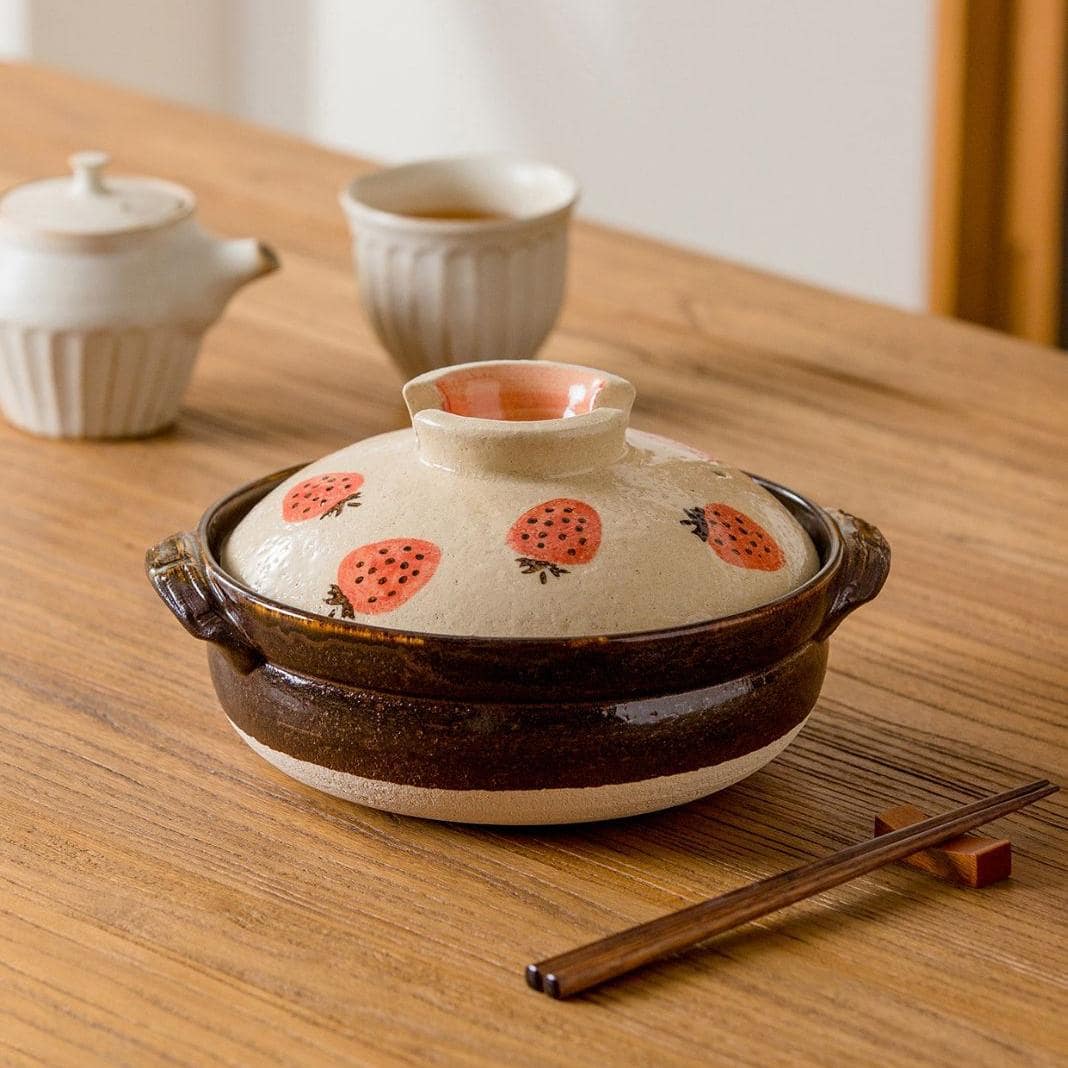 Handcrafted ceramic pot with strawberry design lid.