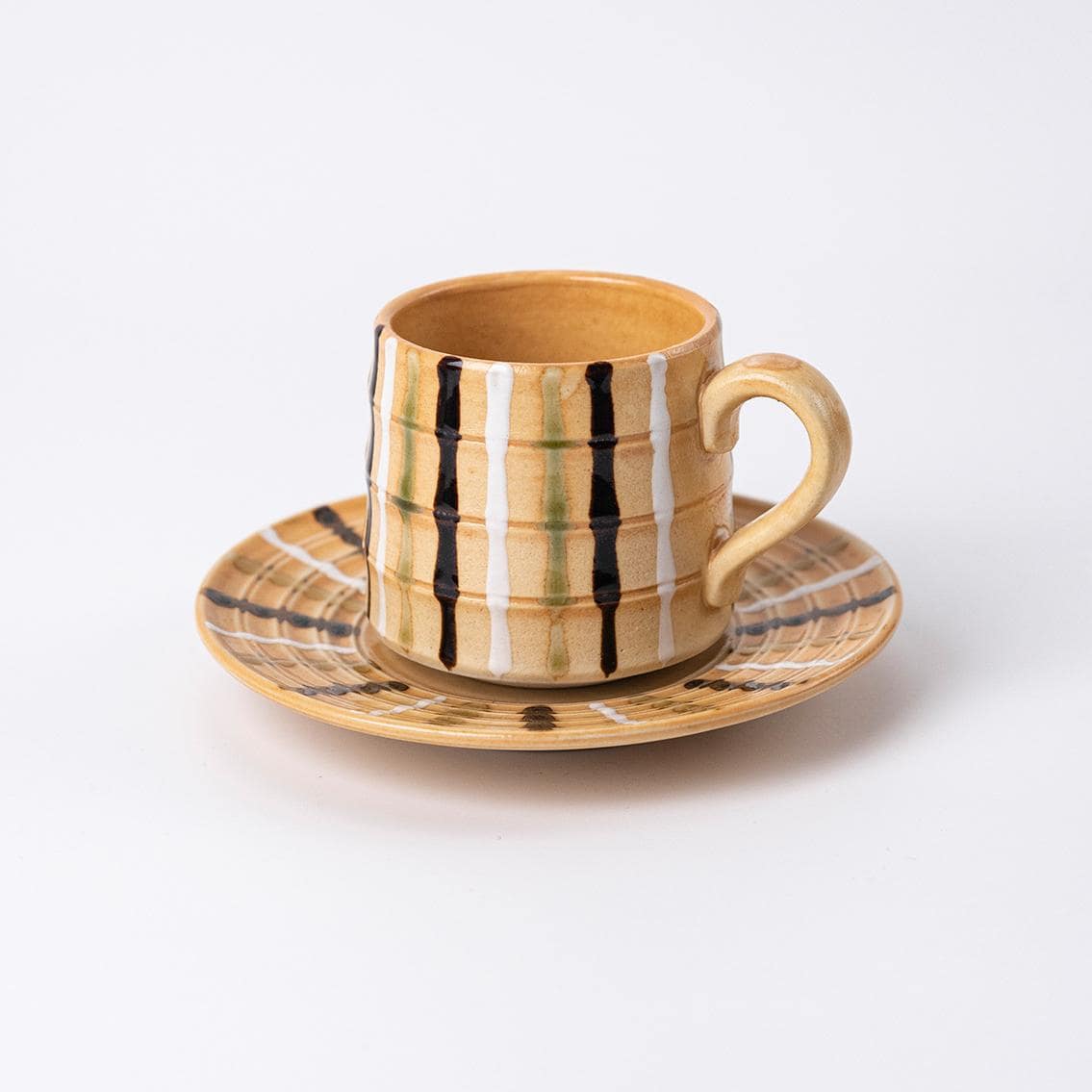 Handcrafted ceramic coffee mug with pink glaze and saucer.