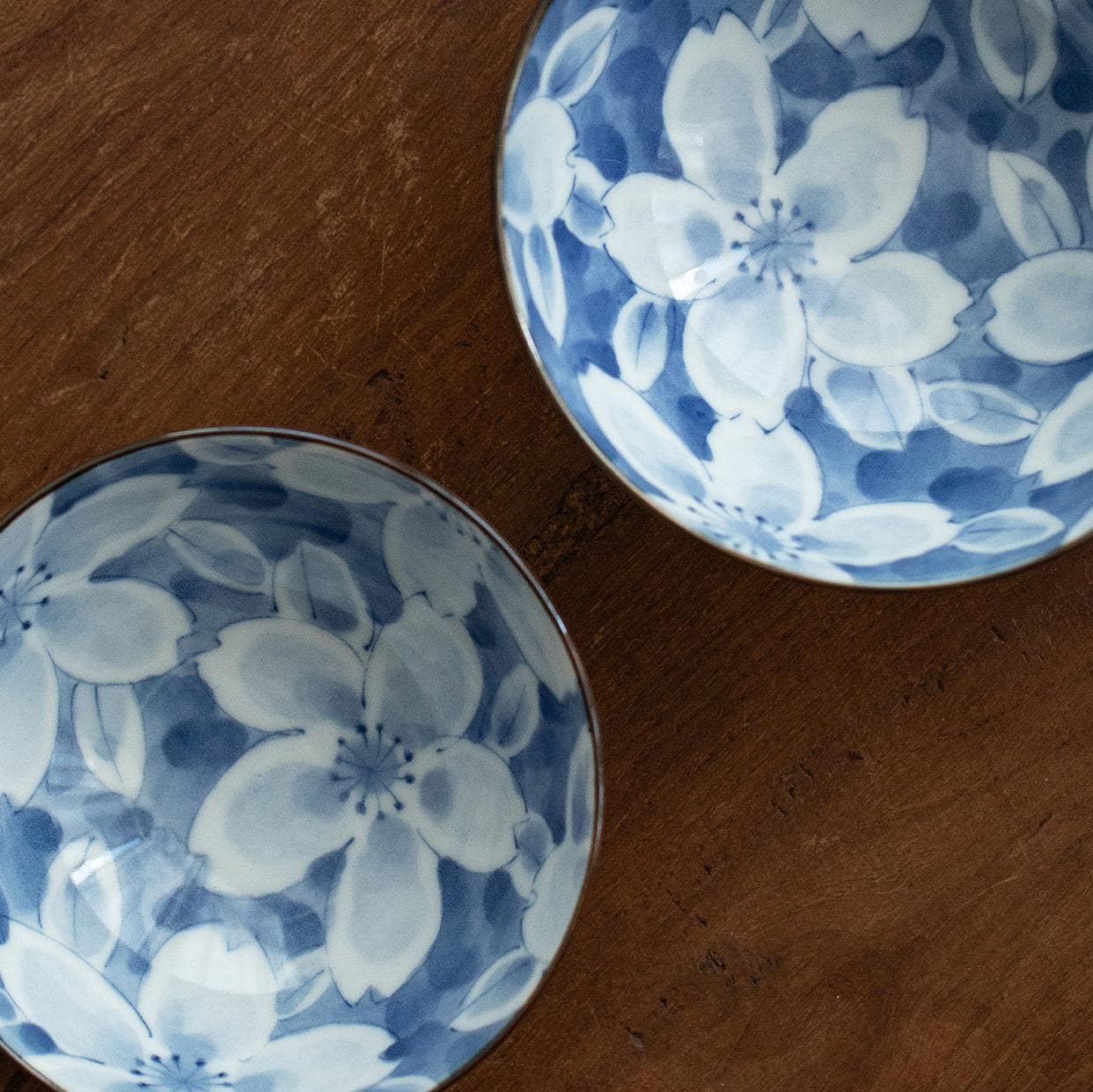 Hand holding a ceramic bowl with rice and chopsticks