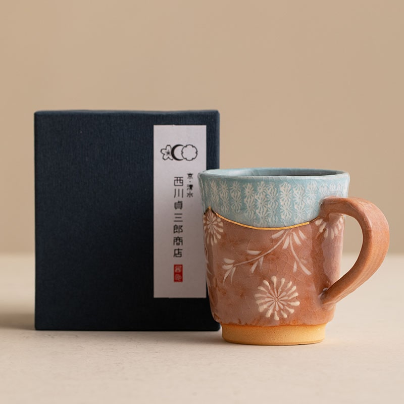 Close-up of a blue and brown ceramic mug with intricate detailing