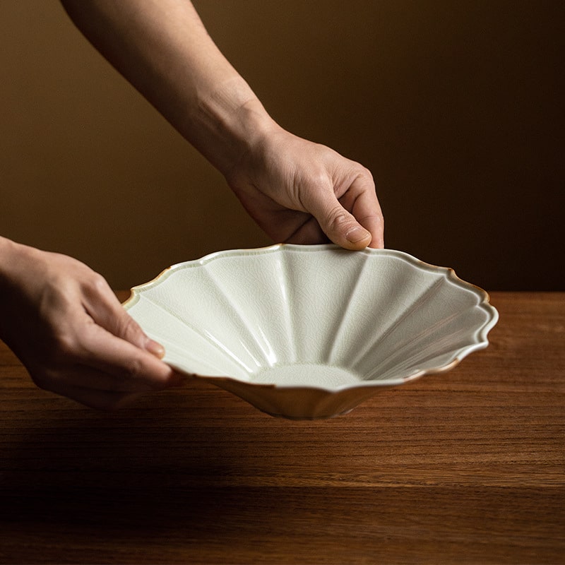 Handcrafted scalloped ceramic plate on a wooden table.