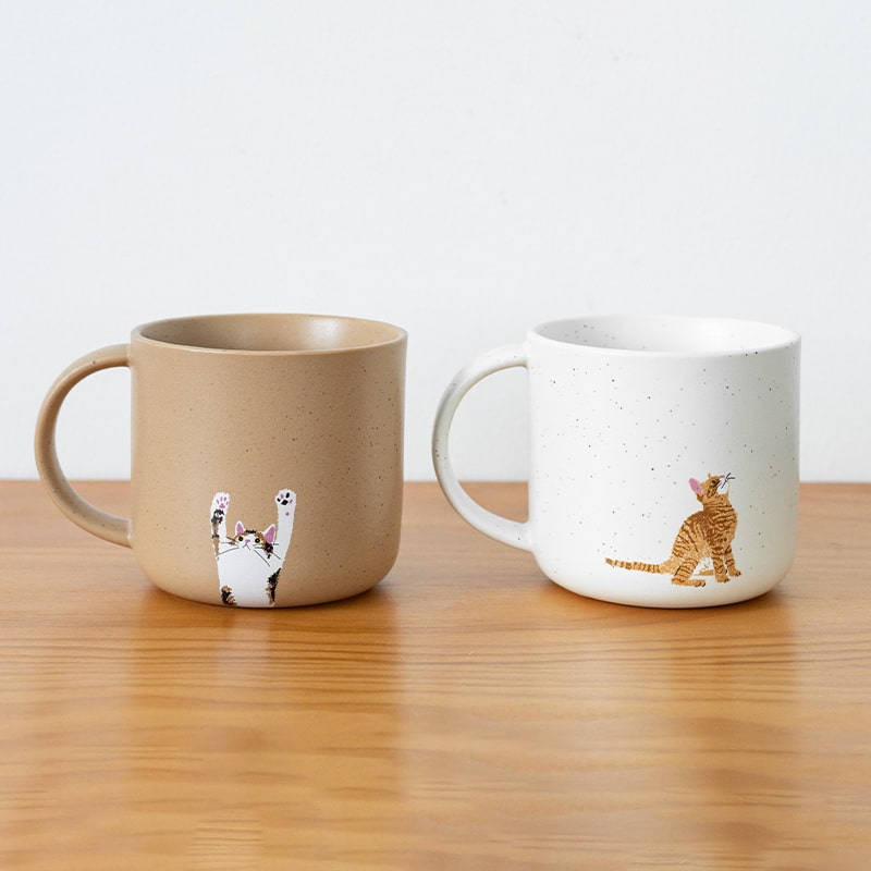 Bottom view of speckled ceramic mugs with paw-print design.