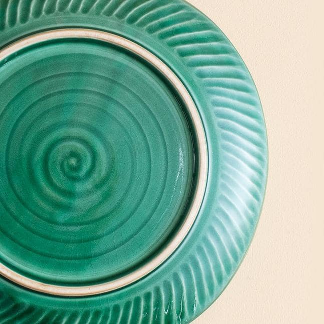 Close-up of green ceramic plate with intricate crackle design.