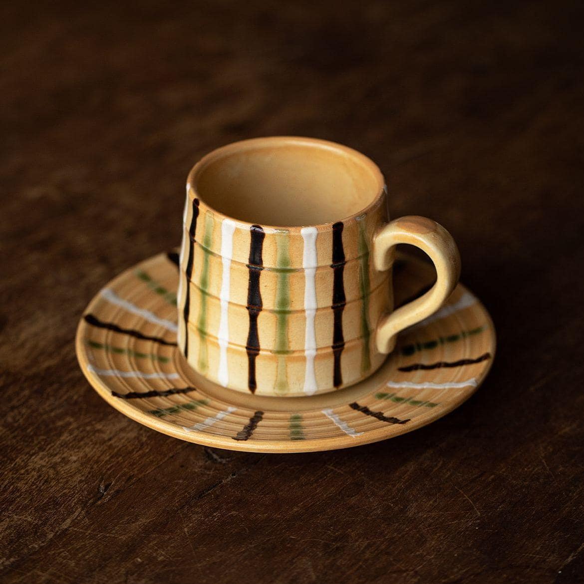 Artisan ceramic mug with textured stripes, perfect for coffee or tea.