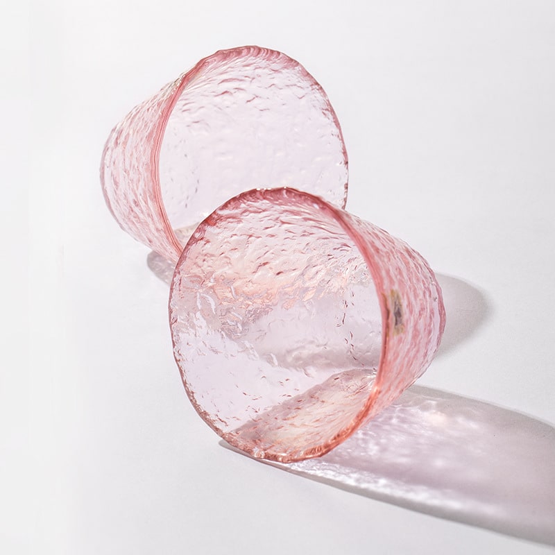 Artistic pink glassware reflecting natural light beautifully.