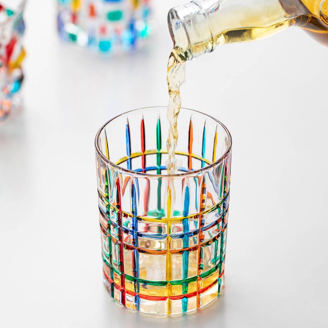 Italian mosaic glassware with colorful reflections on a white background