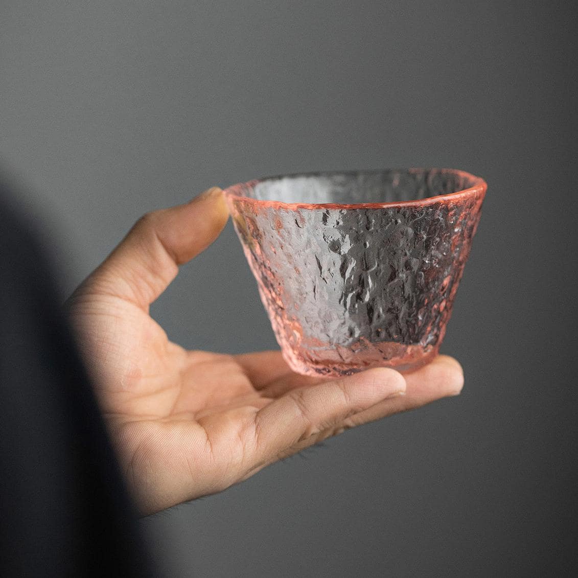 Cherry blossom-inspired pink glass cup with textured finish.