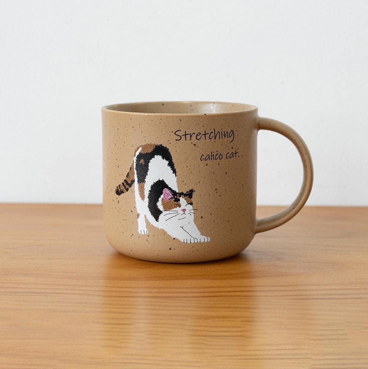 Two adorable ceramic mugs with playful cat illustrations.