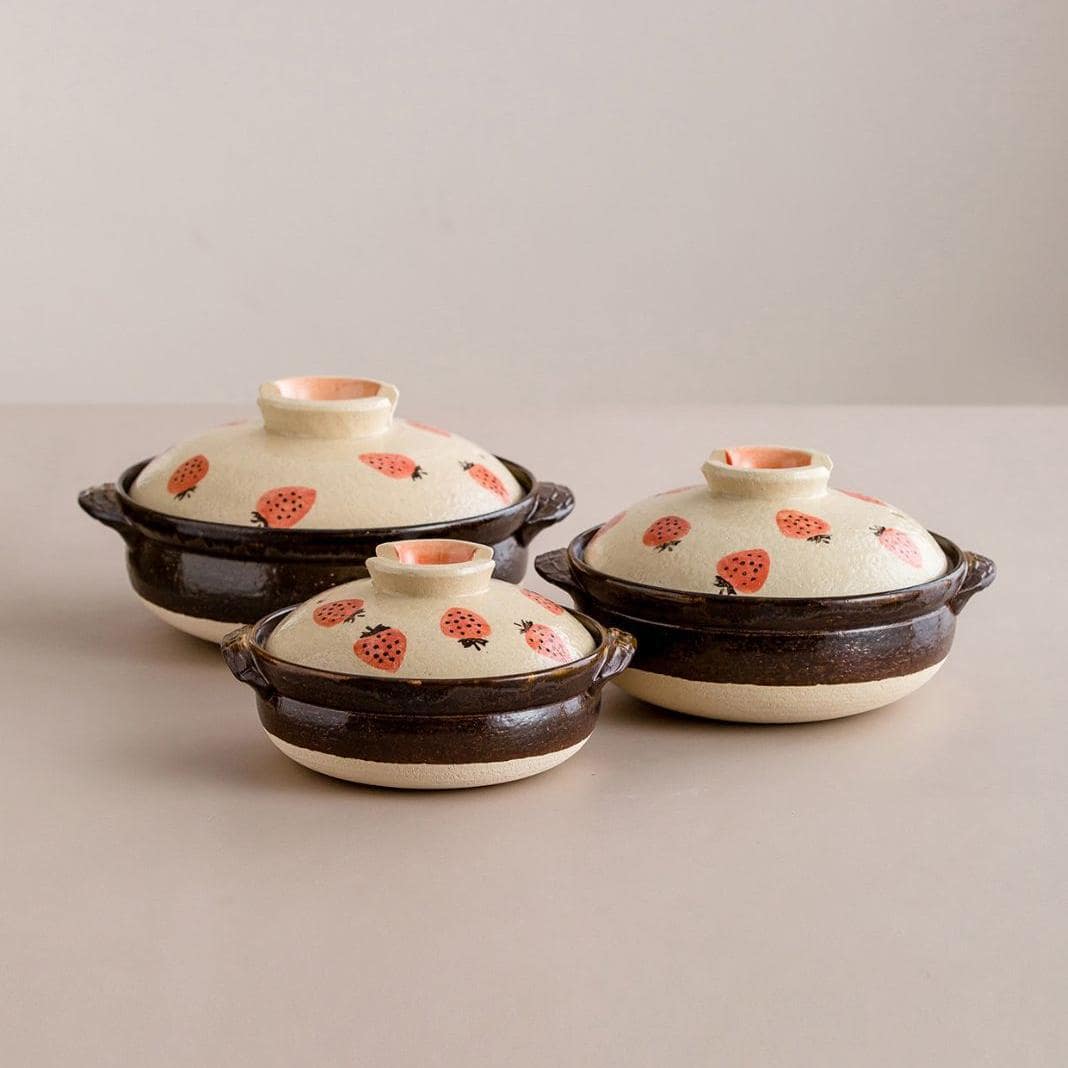 Strawberry-patterned Japanese donabe clay pot on a table.