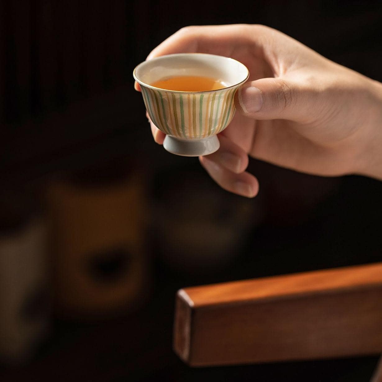 Minimalist Japanese ceramic teapot and teacup on a wooden surface.