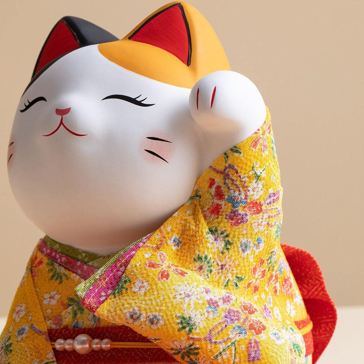 Ceramic lucky cat ornament dressed in a yellow floral kimono