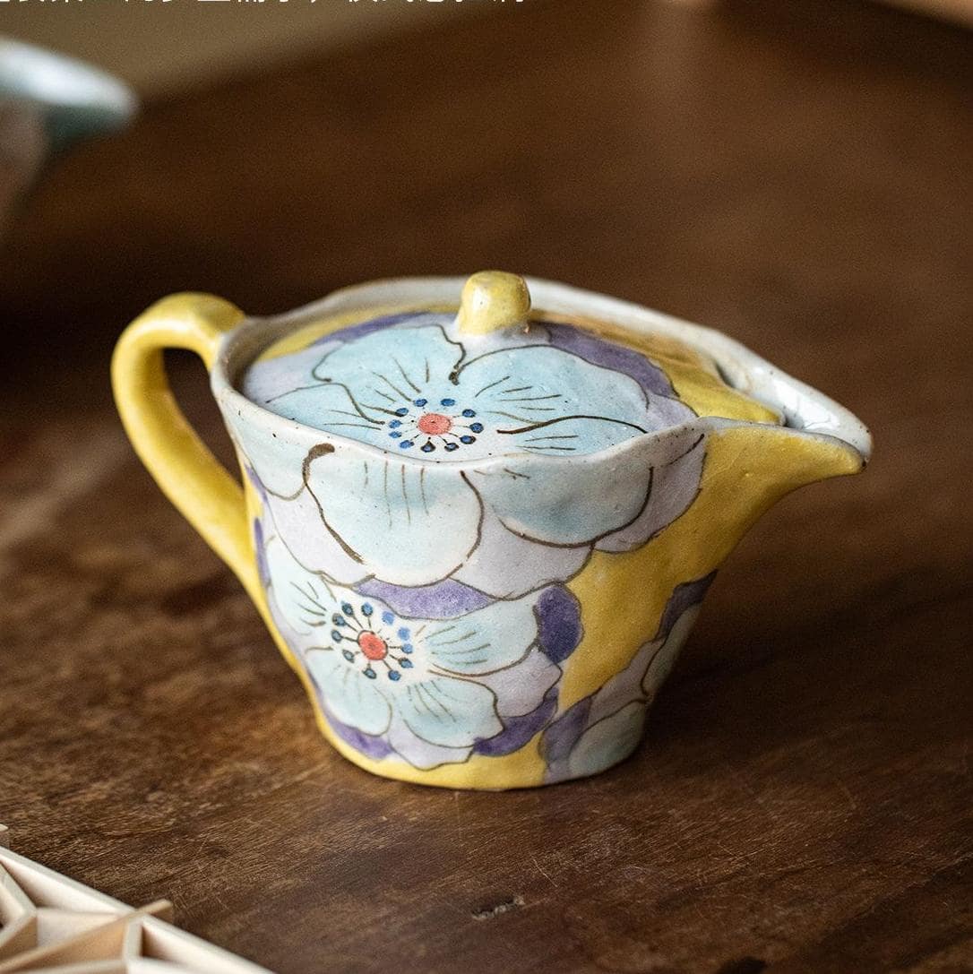 Hand-painted floral ceramic teapot on wooden table