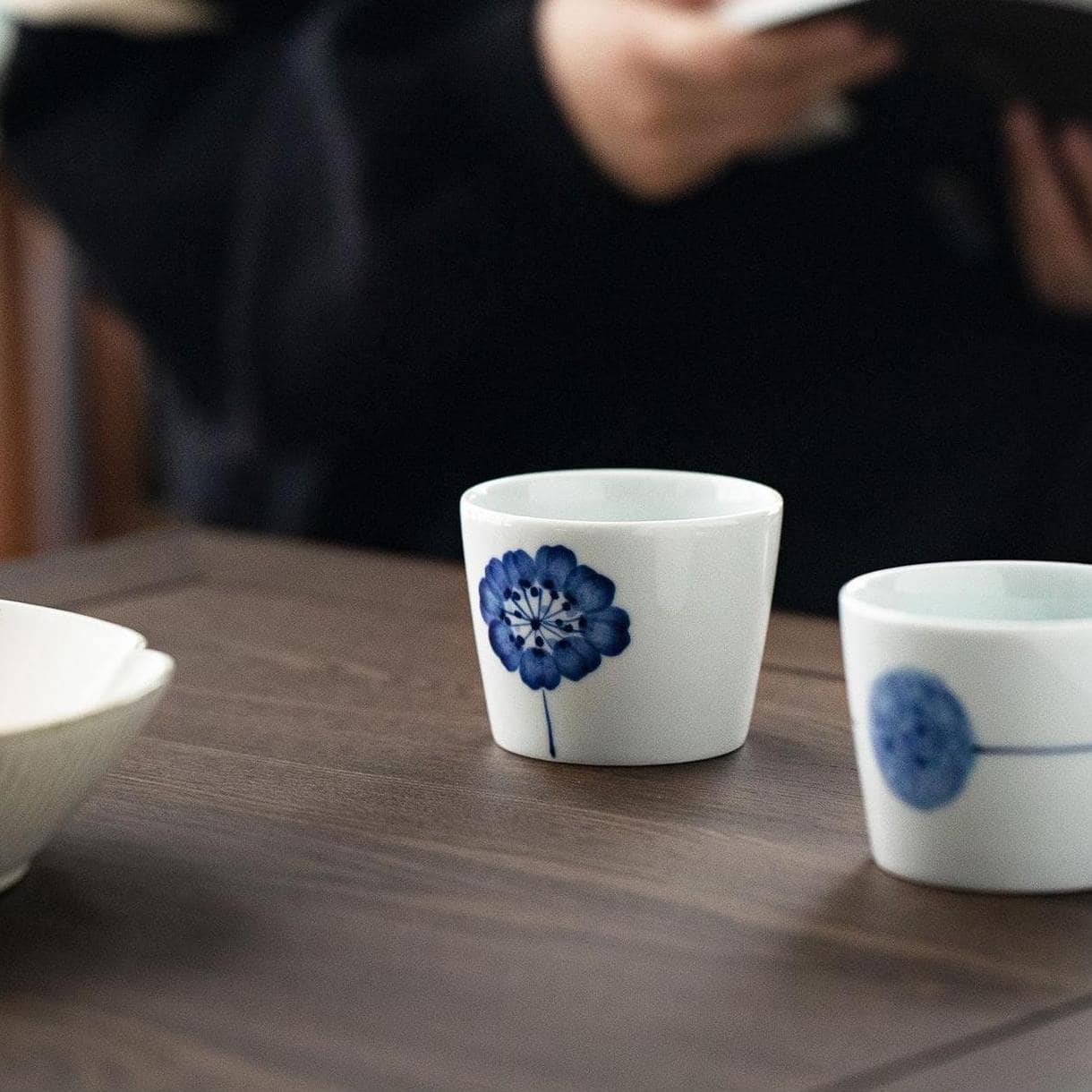 Individual blue and white tea cup with minimalist nature design.