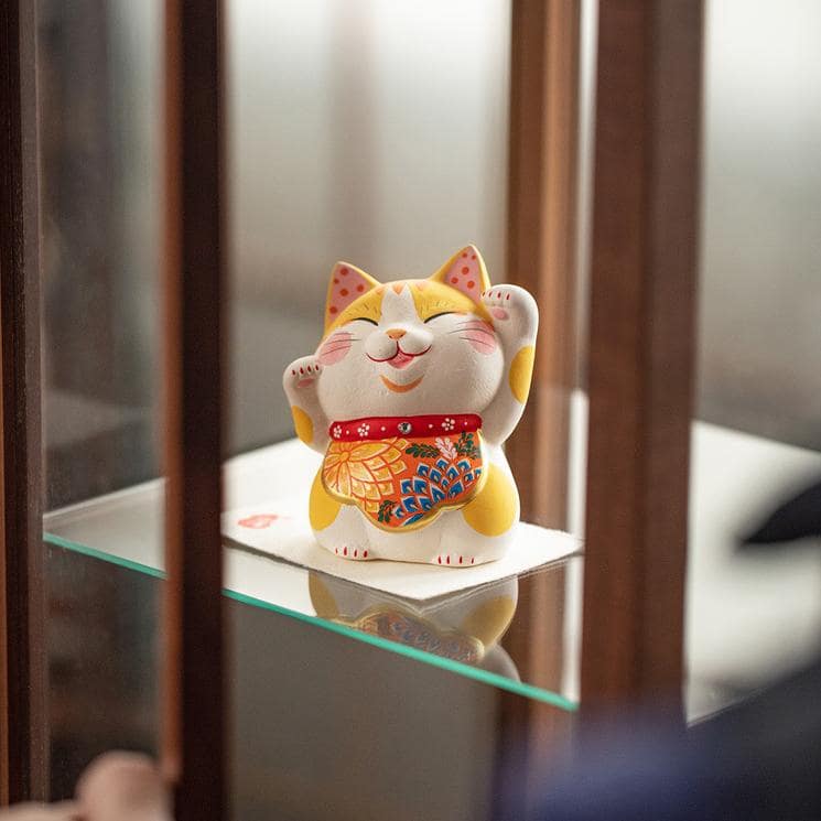 Yellow spotted Lucky Cat waving paw on display