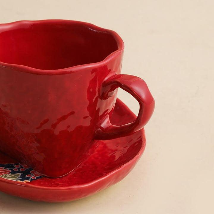 Vibrant red ceramic coffee mug on a textured wooden surface