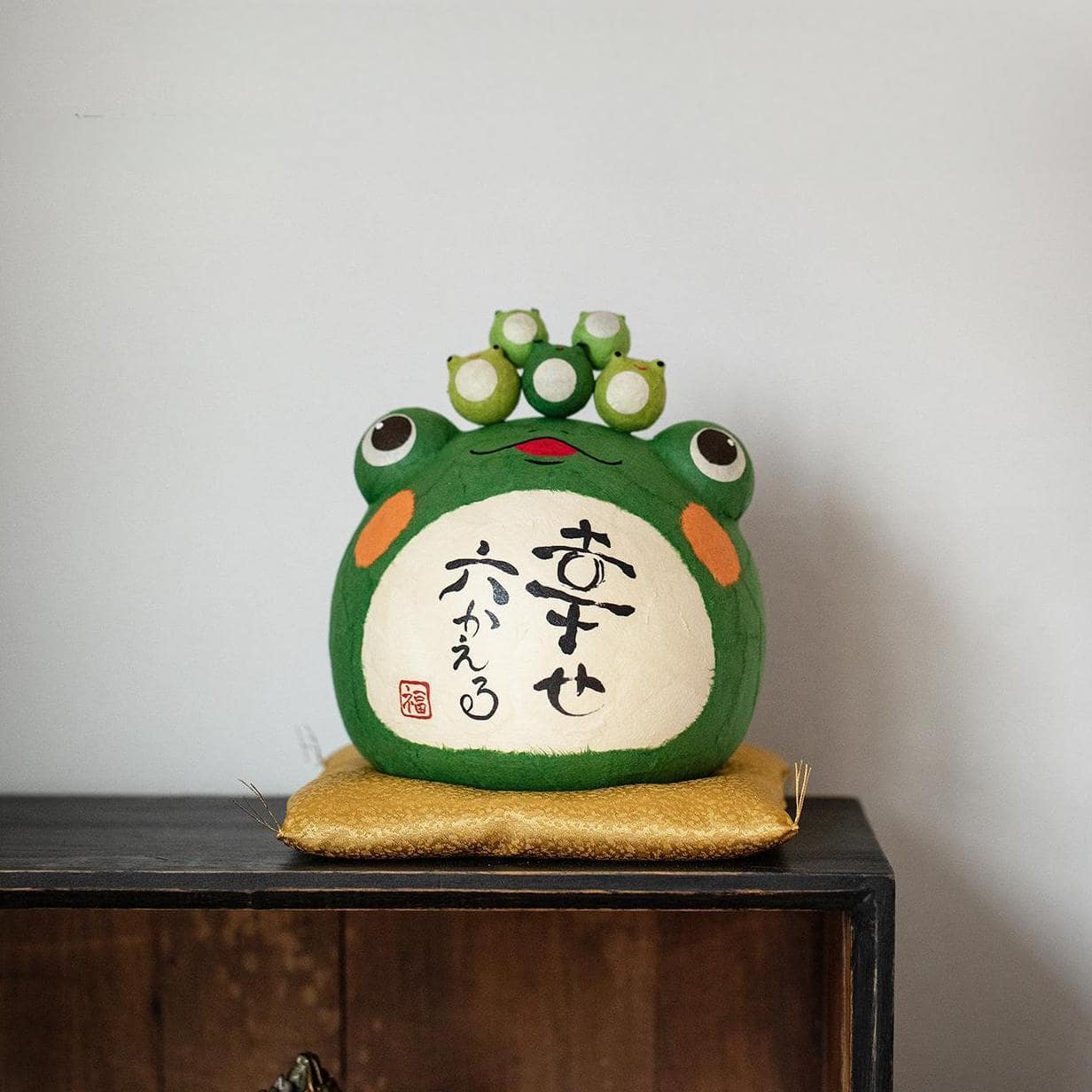 Japanese ceramic frog ornament with lotus leaf and inscriptions.