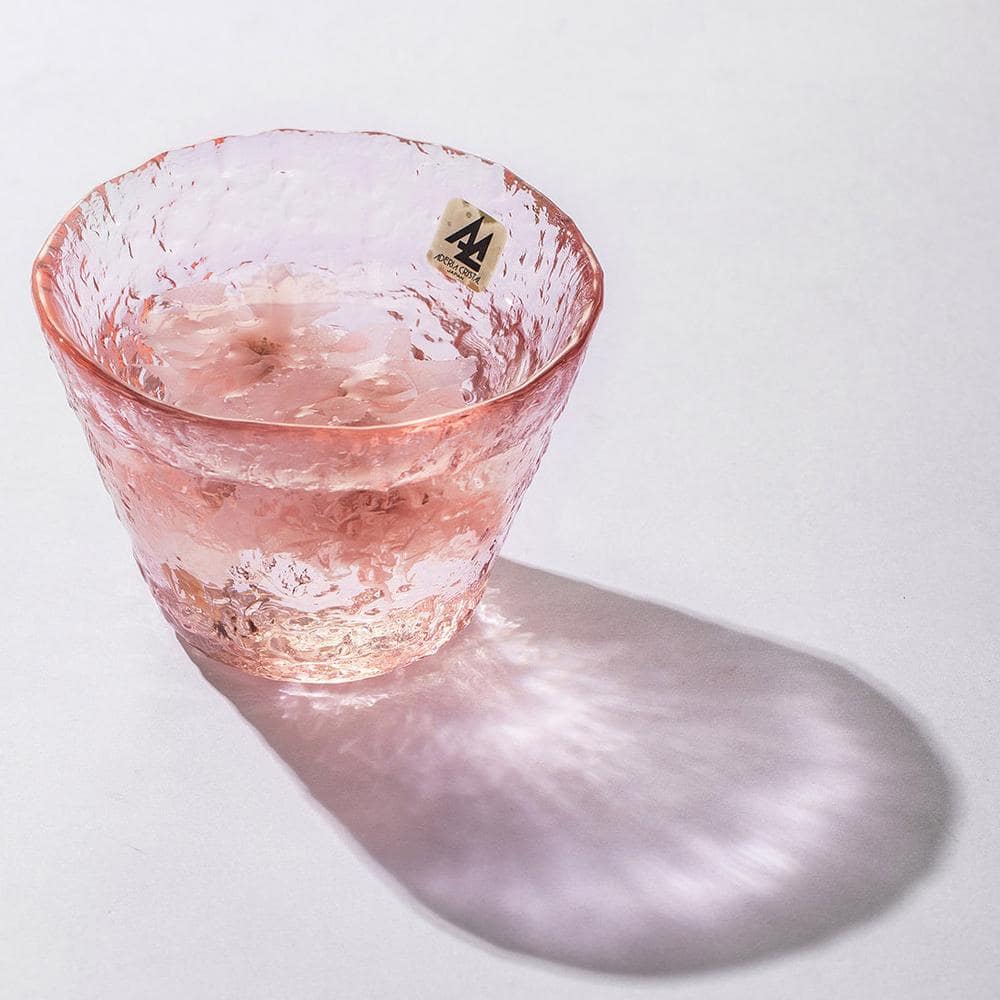 Artistic pink glassware reflecting natural light beautifully.