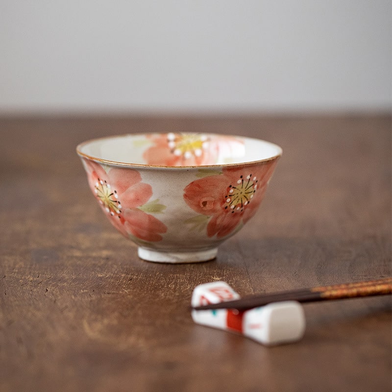 Close-up of sakura-themed ceramic tea cup and matching saucer.