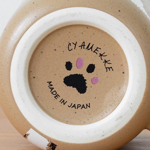 Two adorable ceramic mugs with playful cat illustrations.