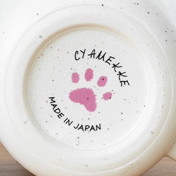 Bottom view of speckled ceramic mugs with paw-print design.