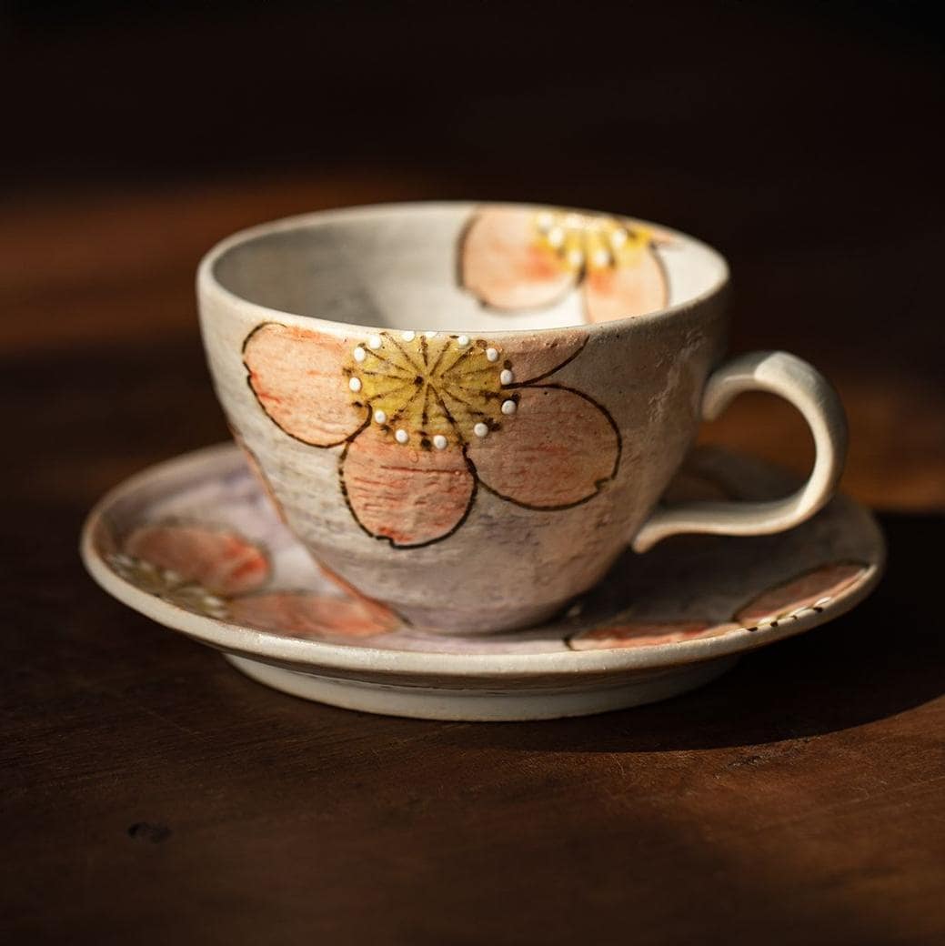 Spring-inspired sakura tea cup and saucer on a wooden table.