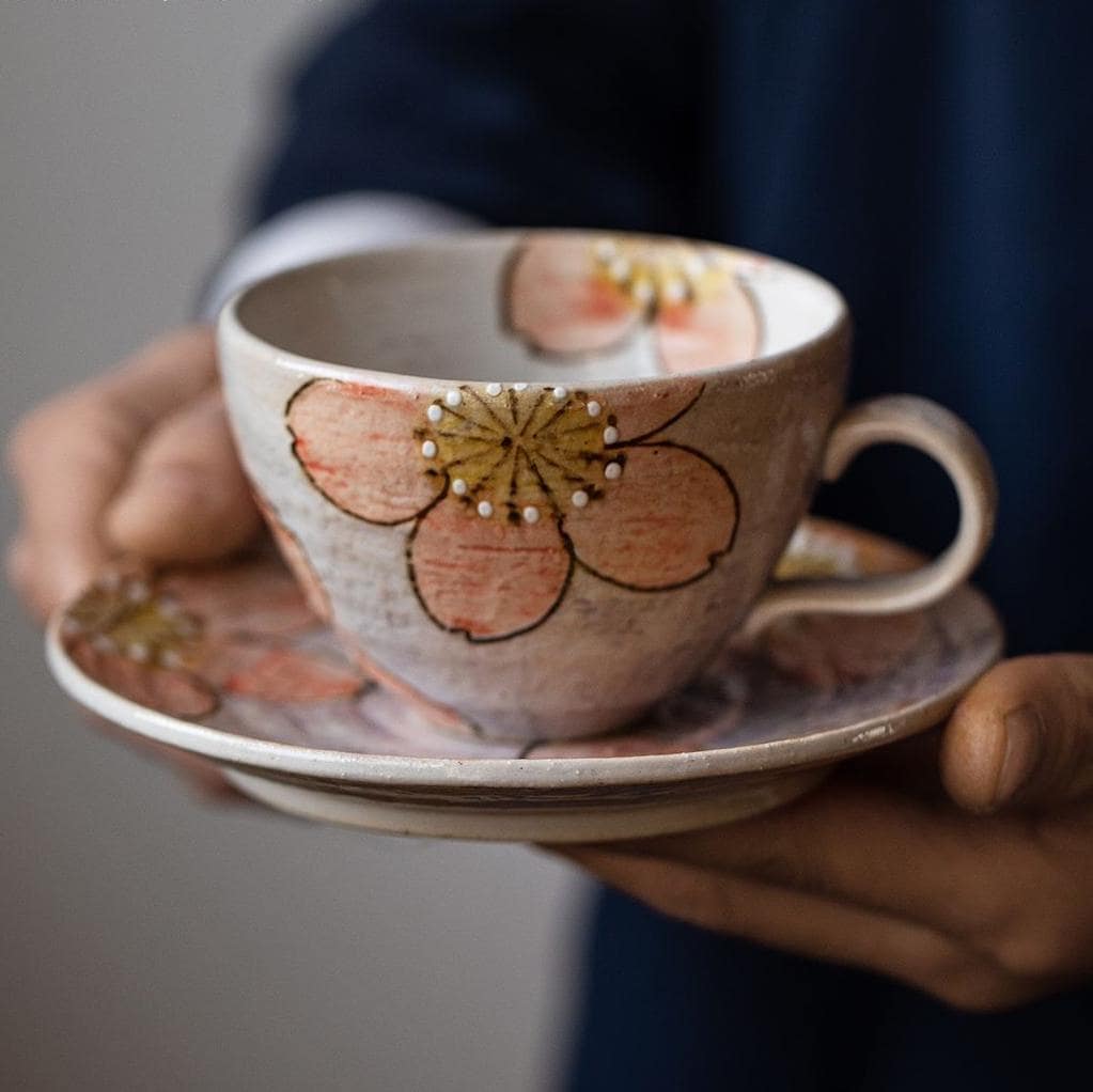 Elegant hand-painted ceramic cup with pastel sakura flowers.