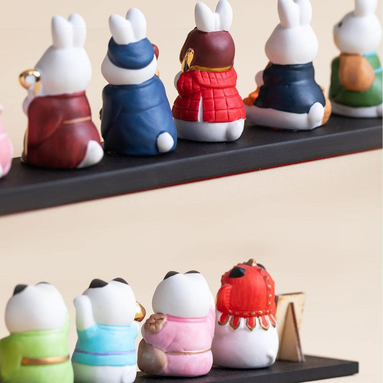 Seven lucky cat servant figurines on display stand