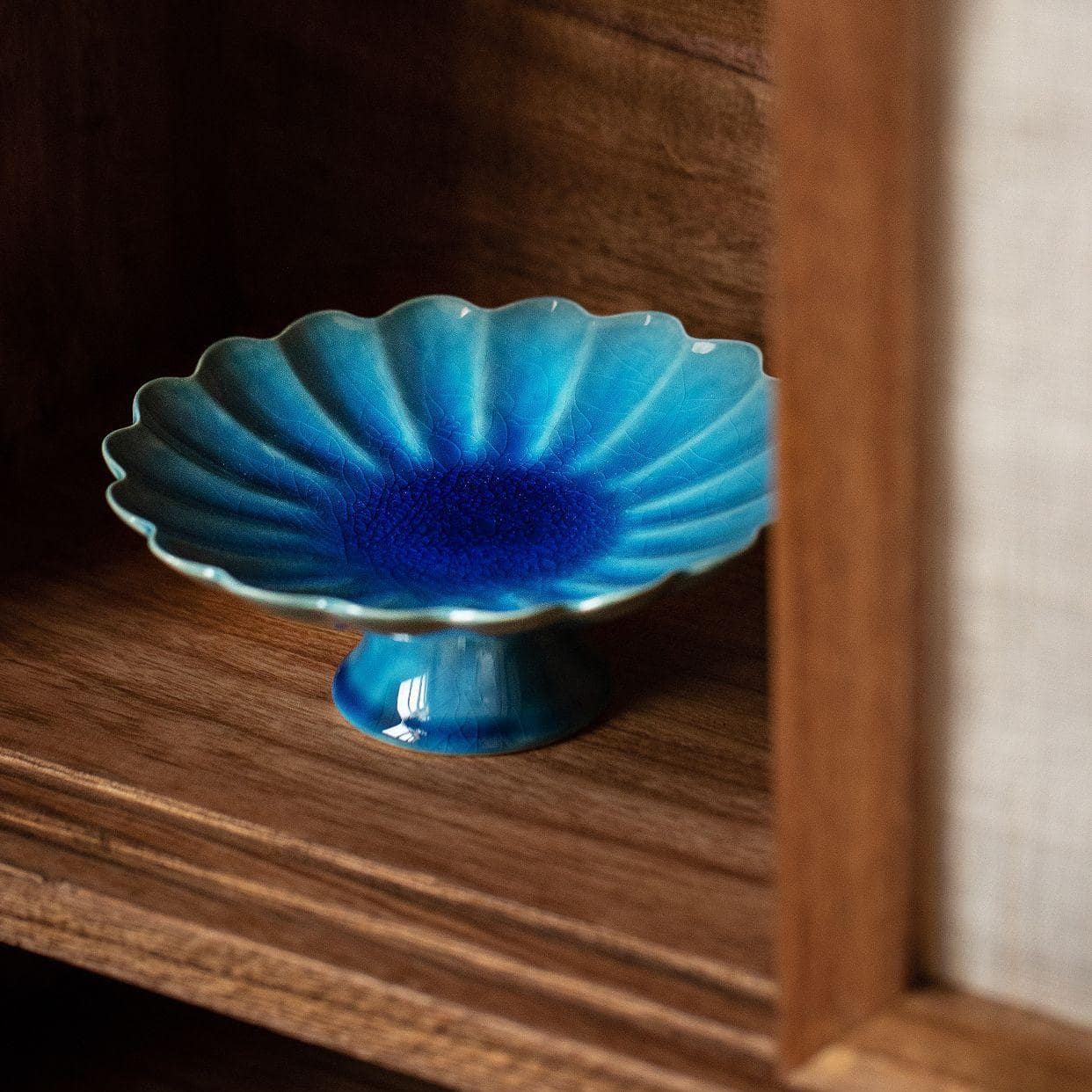 Artistic Japanese chrysanthemum-style ceramic tableware on a wooden table.