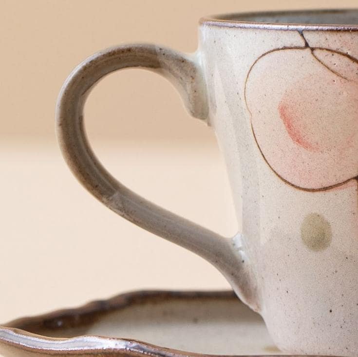 Elegant hand-painted ceramic cup with pastel sakura flowers.