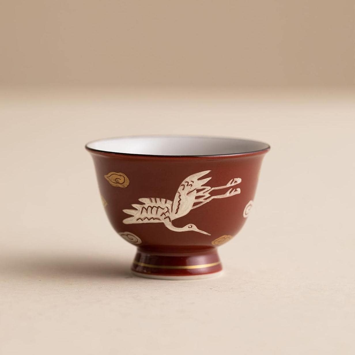 Japanese Kiyomizu-yaki teapot set displayed in a wooden shelf.