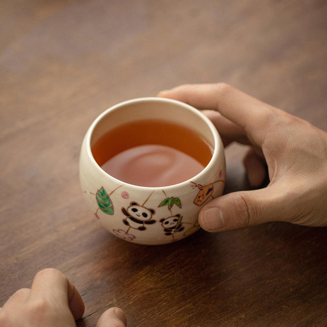 Artistic ceramic tea cups with detailed and vibrant painted patterns.