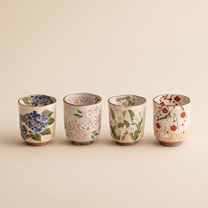 Hand-painted ceramic tea cups featuring seasonal floral designs.