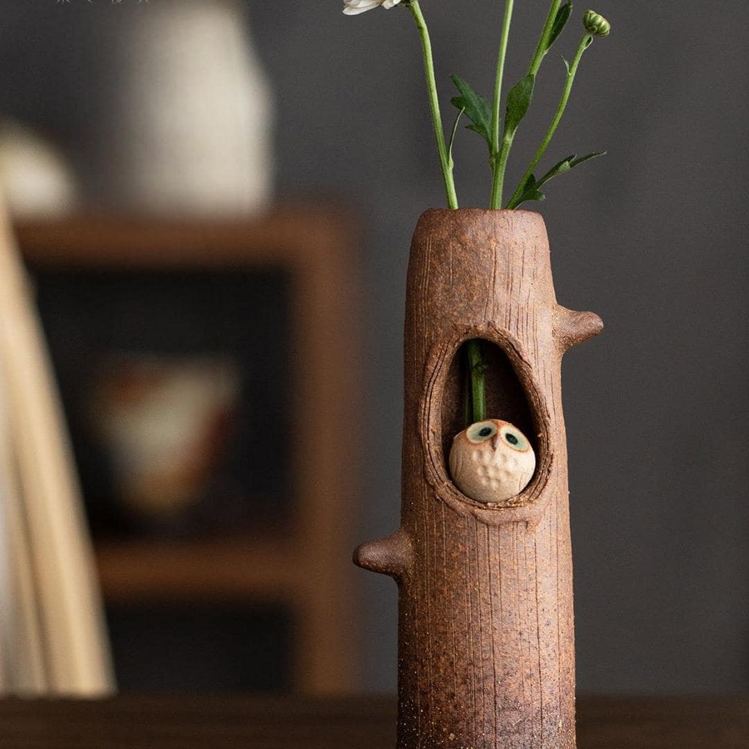 Rustic pottery flower vase with a charming cat design.