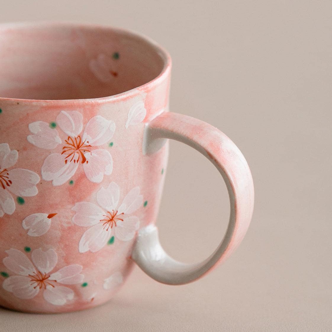 Base of the blue ceramic coffee cup with cherry blossom design.