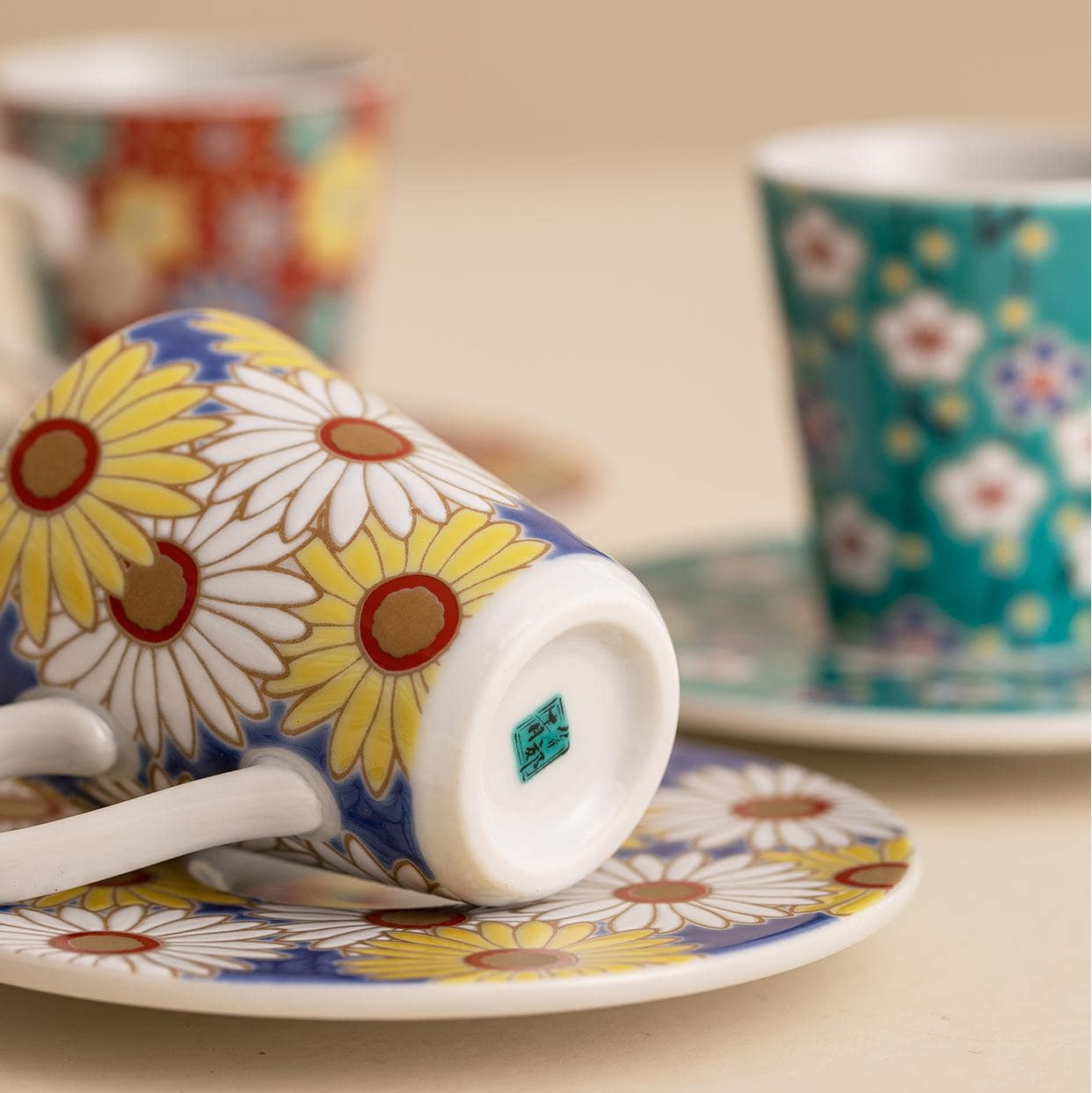 Four espresso cups with distinct vibrant floral designs