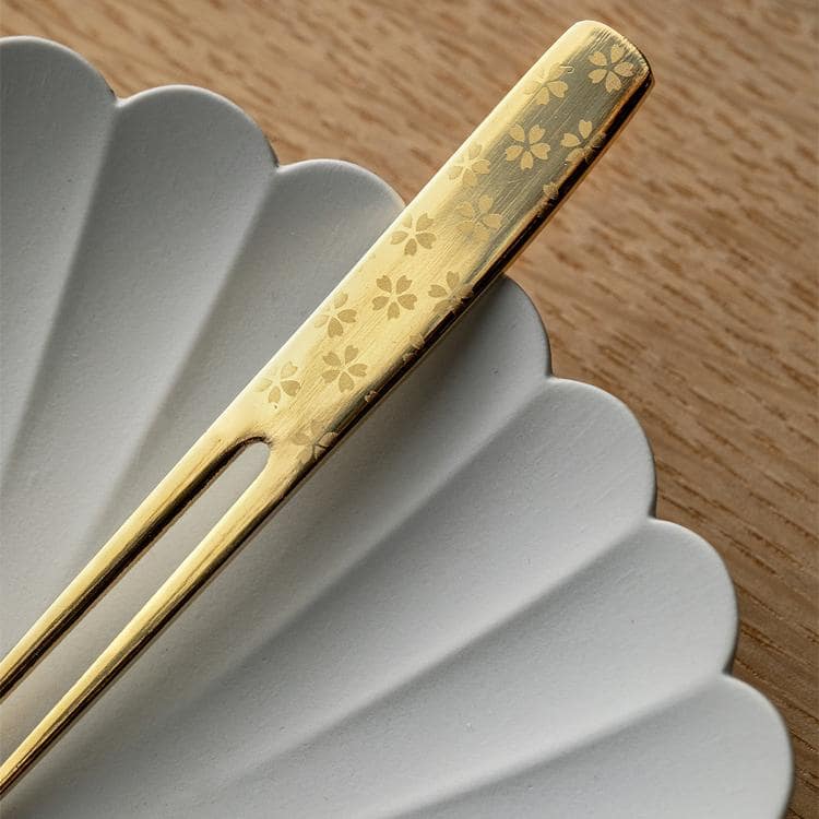 Close-up of the floral-etched gold dessert fork