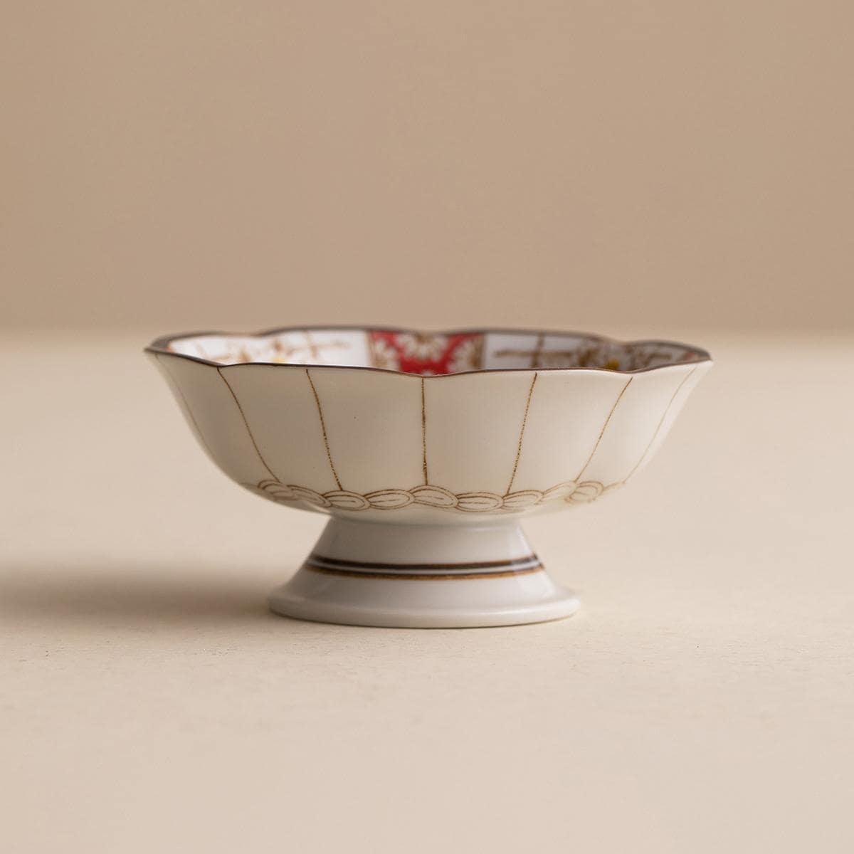 Close-up of Renfeng style tableware showcasing red and gold patterns