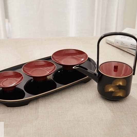 Elegant tea cup set displayed on a beige tablecloth.