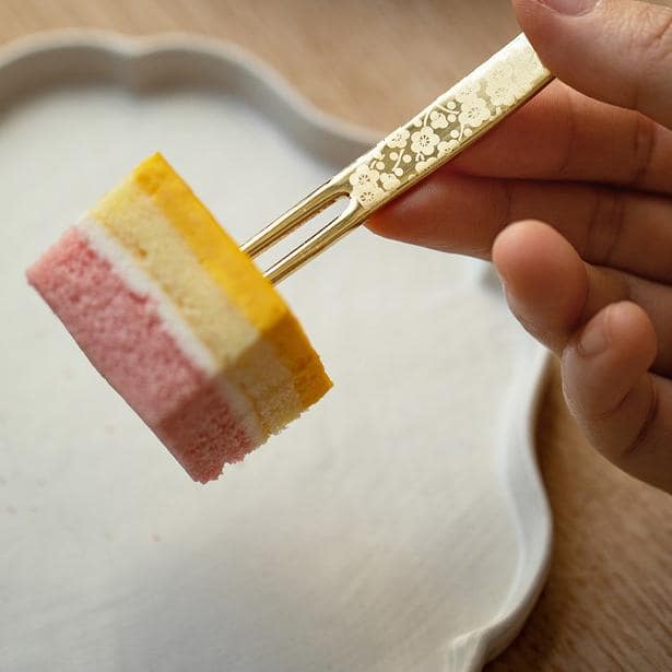 Gold-plated dessert forks arranged with fresh strawberries