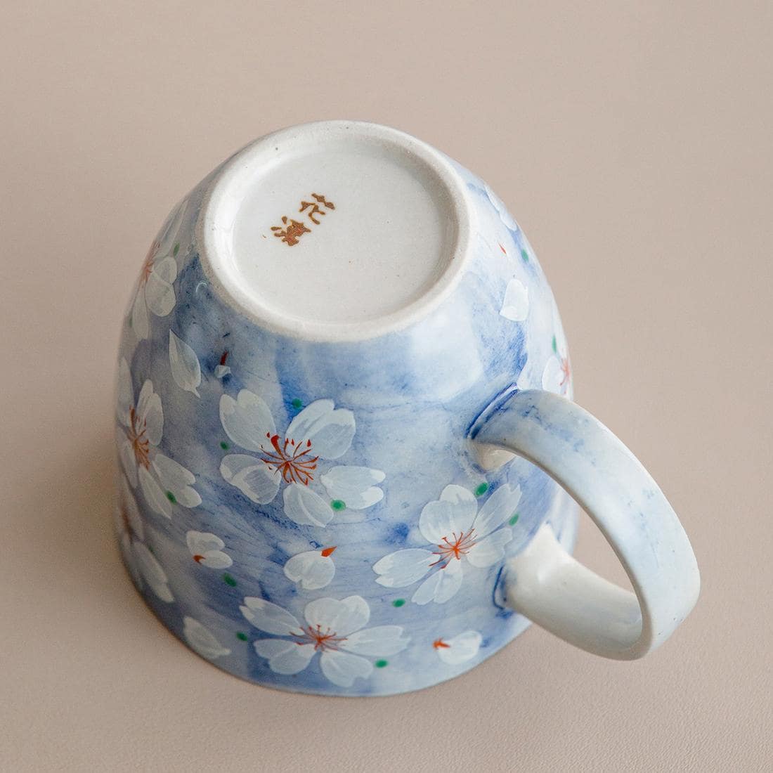 Artistic pink cherry blossom coffee cup, perfect for gifting.